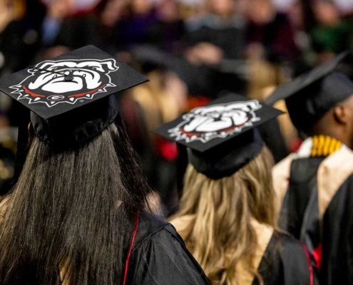 UGA graduates with decorated mortarboards