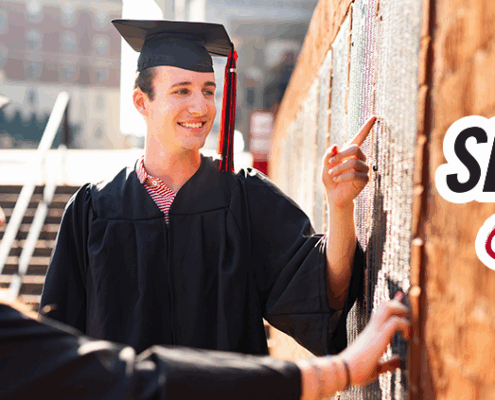 Students find their names on the Senior Signature plaque on campus.