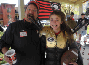 co-founder of UGA Jackson Hole Alumni Chapter and his daughter show off their homemade, golden UGA turnover spikes.