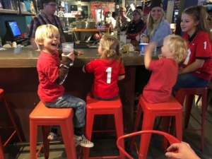 Children decked out in red and black smile while attending a Jackson Hole Alumni Chapter game-watching party. 