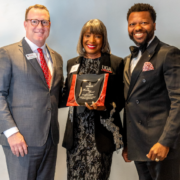 2026FootstepsAward-BlogFeatImage Jeremy Ransom, associate vice president for UGA development and alumni relations (left), and Corey Dortch, president of the UGA Alumni Association (right), presented the 2026 Footsteps Award to DeRetta Rhodes (center) at the annual 1961 Club Celebration in Atlanta in June. Photo credit: Cliff Robinson Photography.