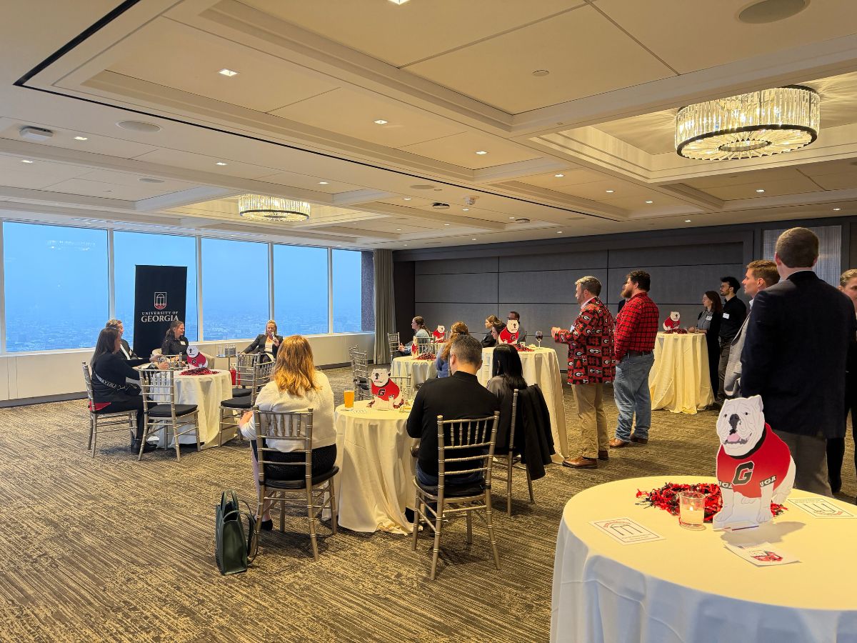 Photo features the layout of the panel event with some guests seated and others standing. Bulldog decor is spread out around the room