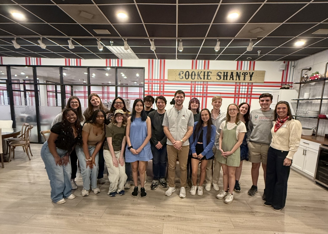 A group photo including Jamie Lindley with several students, all smiling at the camera.