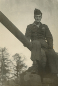 Harold Berkman poses for a picture in his military uniform while sitting on a tank