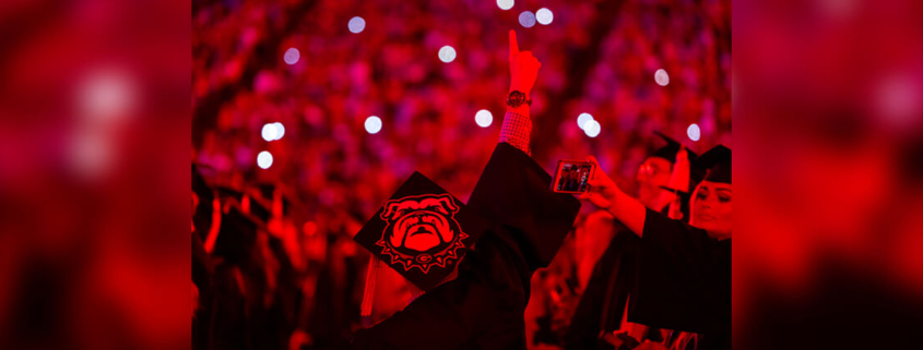 Students are illuminated in red light during Spring 2022 Undergraduate Commencement at Sanford Stadium. (credit: Chamberlain Smith)
