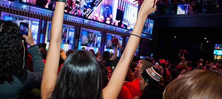 Woman cheering at game watching party.