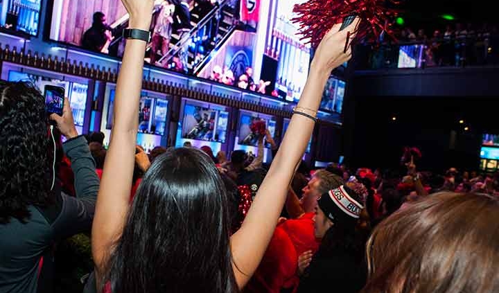 Woman cheering at game watching party.
