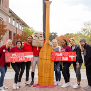 Students and Hairy Dawg stand with the Oar