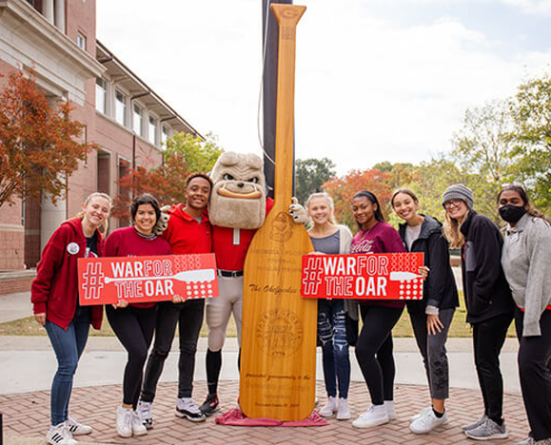 Students and Hairy Dawg stand with the Oar