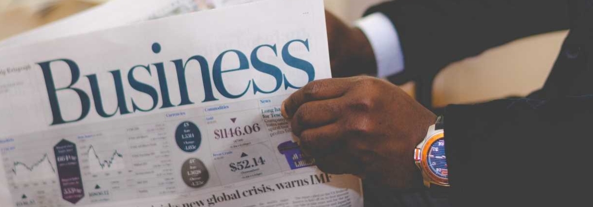 Hands holding business newspaper