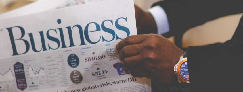 Hands holding business newspaper