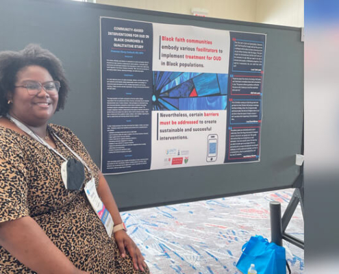 Ebony Caldwell poses next to her research poster.