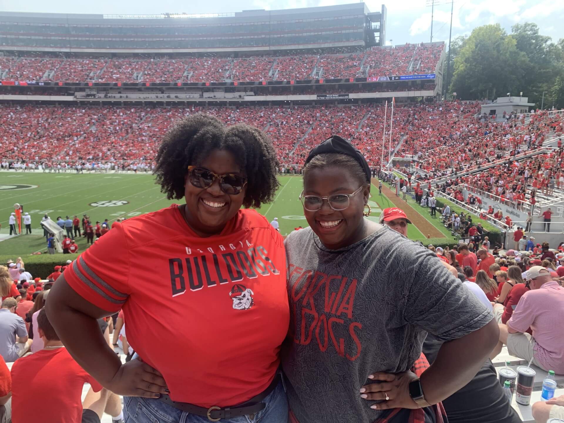 Charlene's daughters pose in the stands at a UGA football game